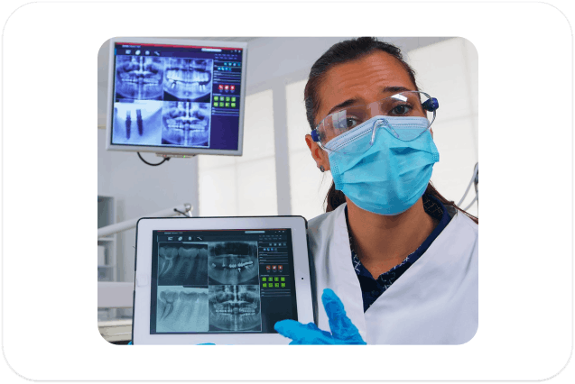 Dentist explaining dental X-ray to patient using digital screen
