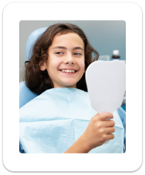 Pediatric patient smiling while holding dental mirror